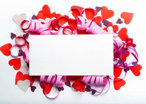 Творческая компоновка из цветных бумажных сердец и прямоугольного клочка бумаги, помещенного в центре. Валентин с местом для смс. Концепция празднования . — стоковое фото