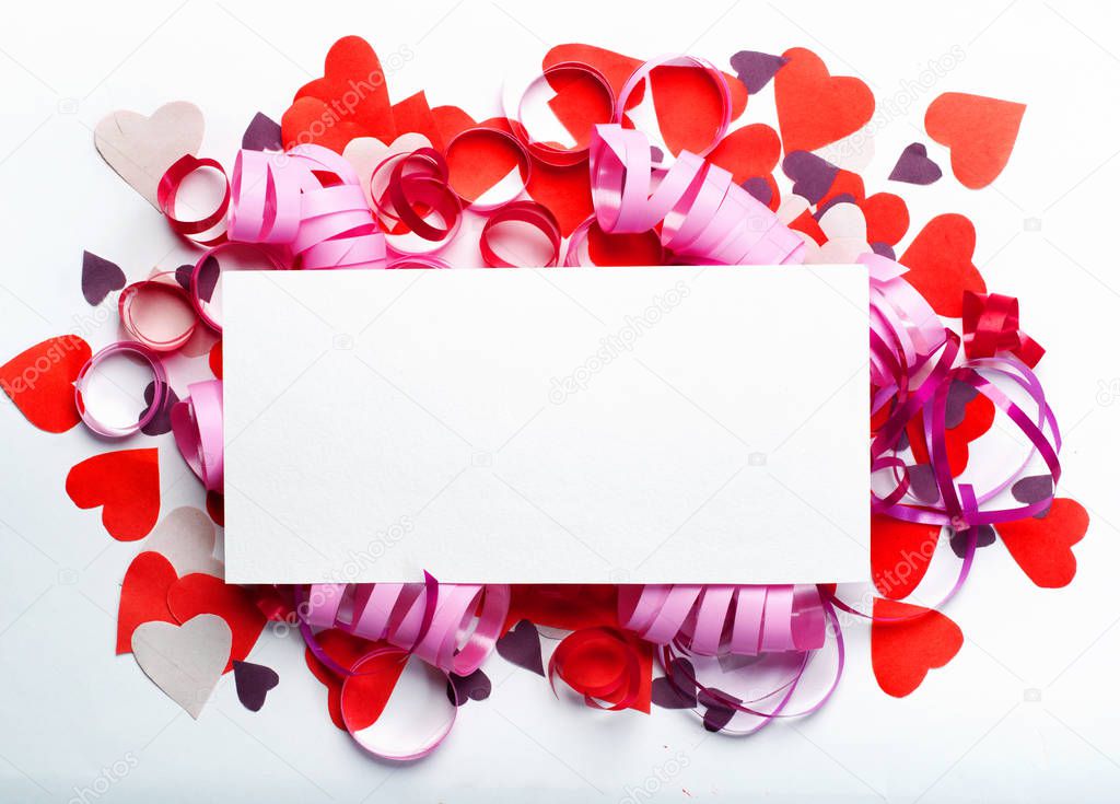 Creative layout made of colored paper hearts and a rectangular scrap of paper placed in the center. Valentine with place for text. Celebration concept.