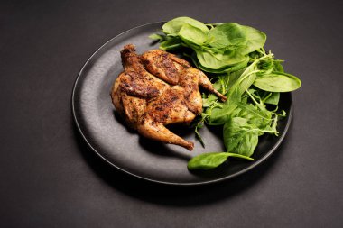 Siyah zemin üzerinde kızarmış bıldırcın (kuş). Hazır.