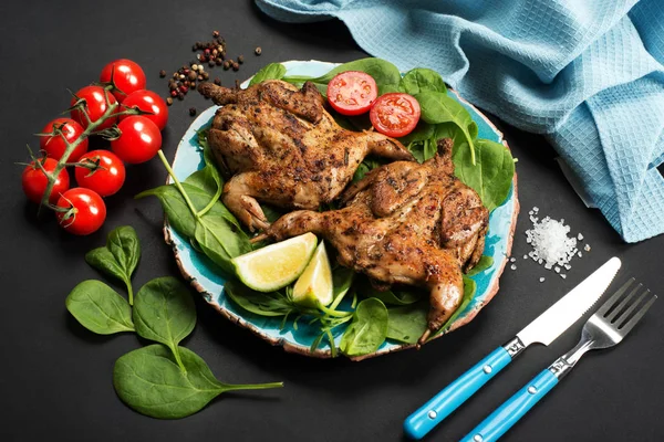 Codorniz asada (ave) en un plato azul, junto a espinacas y cereza — Foto de Stock