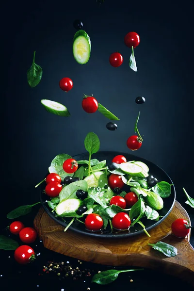 Tomaten Spinatblätter Und Gurkenscheiben Die Eine Salatschüssel Fallen Dunkler Hintergrund — Stockfoto