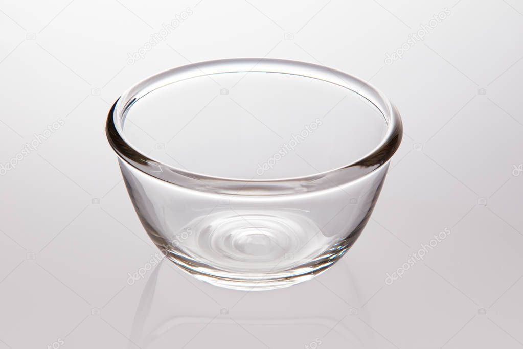 Single clear glass bowl on light gray background