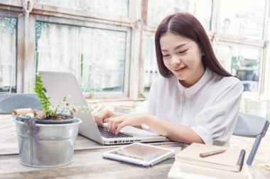 Genç casual Asyalı kadın teknolojisini kullanarak