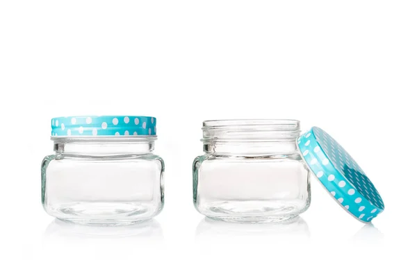 Dos frascos de vidrio vacíos con tapa azul punteada sobre fondo blanco — Foto de Stock