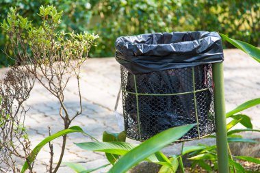 siyah plastik çöp kutusuna bir patika boyunca metal konteyner
