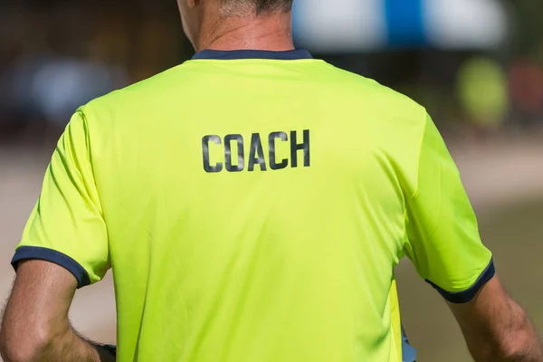 Спинка тренера яскраво-зеленої кольорової сорочки зі словом Тренер w — стокове фото