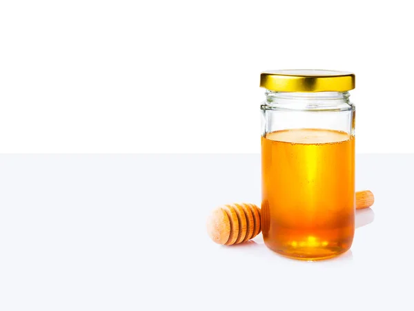 Miel en tarro de vidrio y tarro de miel de madera en blanco y claro gr — Foto de Stock