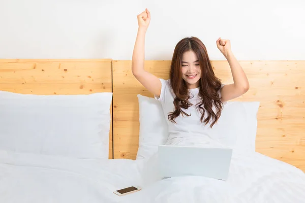 Щаслива молода красива азіатська жінка прокидається в ліжку, схвильована — стокове фото