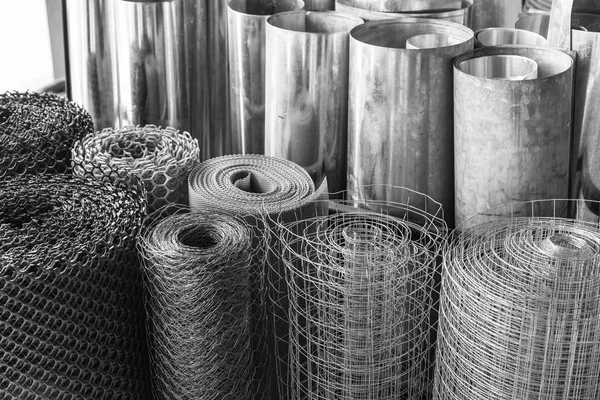 Rolls of galvanized metal sheets, steel chicken wire mesh, and p — Stock Photo, Image