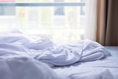 Beyaz çarşaf ve battaniye, parlak sabah hafif co dağınık yatak