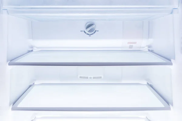 inside of clean and empty refrigerator with shelves