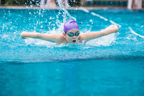 Pojke simmare simning fjärilsim i en fin klar simning p — Stockfoto