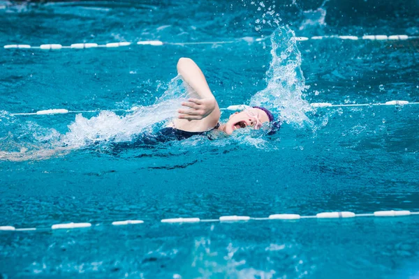 Flicka simmare simma ursinnigt i freestyle stroke i en fin klar — Stockfoto
