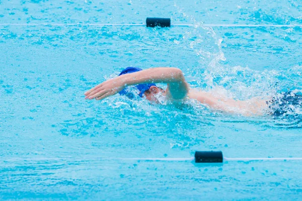 Manliga simmare simning freestyle stroke i en pool — Stockfoto