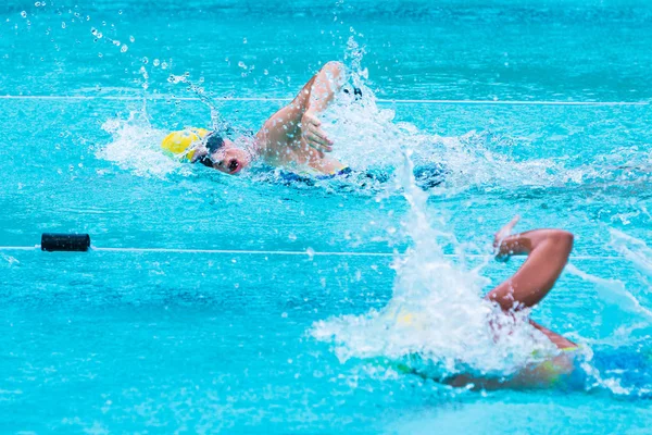 Jonge vrouwelijke zwemmers race in vrije stijl slag bij een school swimm — Stockfoto