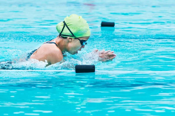 Unga kvinnliga simmare raser i andedräkt stroke och höjer upp till katt — Stockfoto