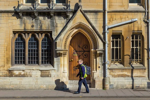 Hombre caminando en la acera frente a un viejo edificio de Oxford Un —  Fotos de Stock