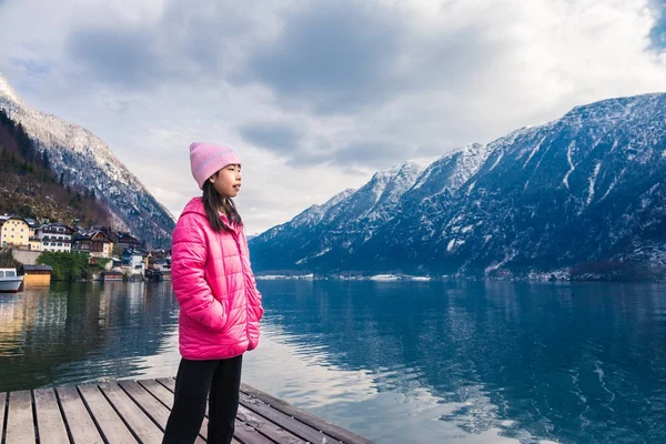 Kız pembe kış bez staning bulanık kasaba ile bir gölün yanında bir — Stok fotoğraf