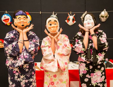 Asian tourists wearing Japanese funny folk character masks and t clipart