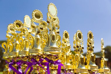 Açık bir masada hazır sıraya parlak altın spor kupa