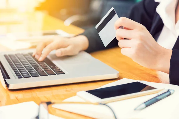 Business woman holding credit card and using computer to make he