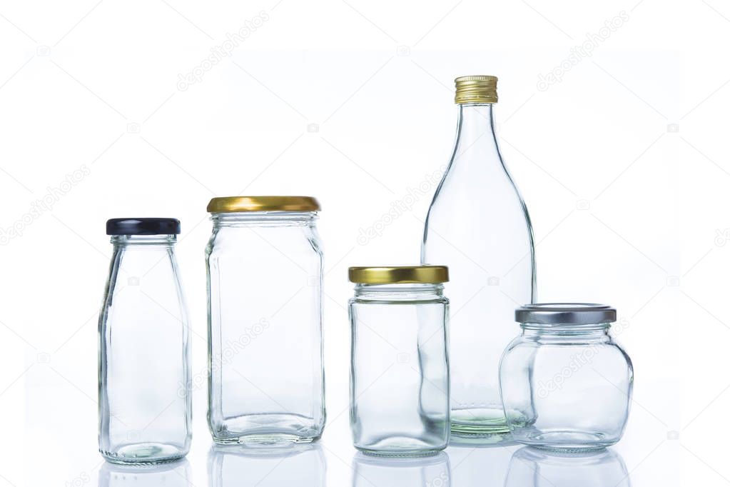 Clear glass bottles in various sizes and shapes with lids on whi