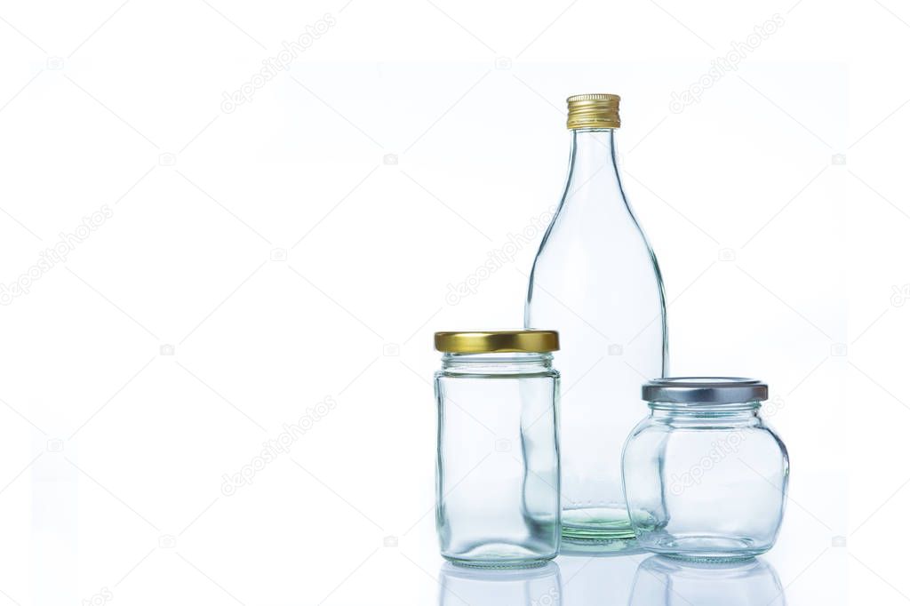 Clear glass bottles in various sizes and shapes with lids on whi