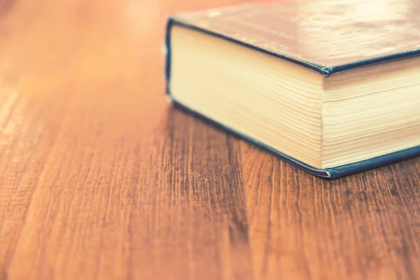 Viejo libro de tapa dura gruesa sobre mesa de madera — Foto de Stock