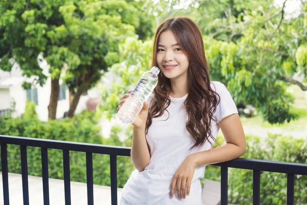 Mutlu çekici genç Asyalı kadın bir bot holding beyaz tshirt — Stok fotoğraf