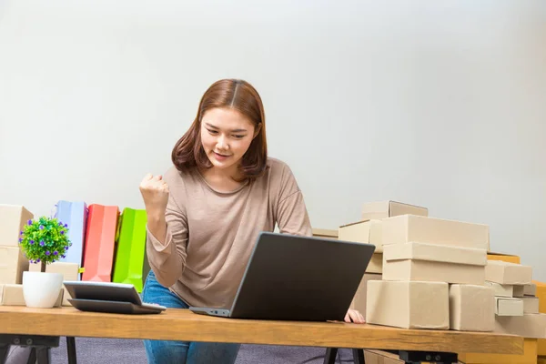 Young asian online seller businesswoman in her home office holdi