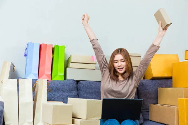 Young asian online seller businesswoman in her home office holdi