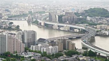 Fukuoka şehrindeki iş ve emlak binalarının havadan görünüşü ve ekspres yolu Japonya 'nın Fukuoka kentindeki nehrin üzerinden geçiyor.