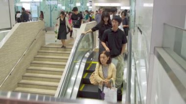 Fukuoka, Japonya - 13 Temmuz 2019 - İnsanlar 13 Temmuz 2019 tarihinde Japonya Fukuoka'daki alışveriş merkezi binalarından birinde katyukarı inmek için yürüyen merdiven kullanıyor