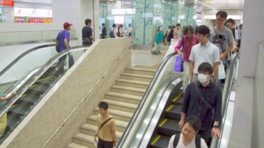 Fukuoka, Japonya - 13 Temmuz 2019 - İnsanlar 13 Temmuz 2019 tarihinde Japonya Fukuoka'daki alışveriş merkezi binalarından birinde katyukarı inmek için yürüyen merdiven kullanıyor