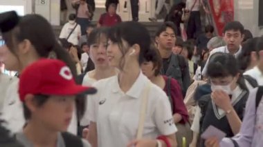 Fukuoka, Japonya - 13 Temmuz 2019 - İnsanlar 13 Temmuz 2019 tarihinde Fukuoka, Japonya 'da bir tren istasyonunun çıkışında yürürler.