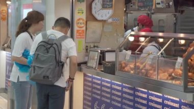 Fukuoka, Japonya - 13 Temmuz 2019 - İnsanlar 13 Temmuz 2019 tarihinde Fukuoka, Japonya 'daki tren istasyonu yakınlarındaki fırından kruvasan ve diğer fırınları satın alır.