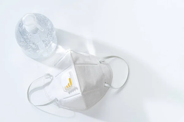 Beyaz masa üzerinde antiseptik el jeli ve N95 maskesi, sağlık konsepti, fotokopi alanı için yer