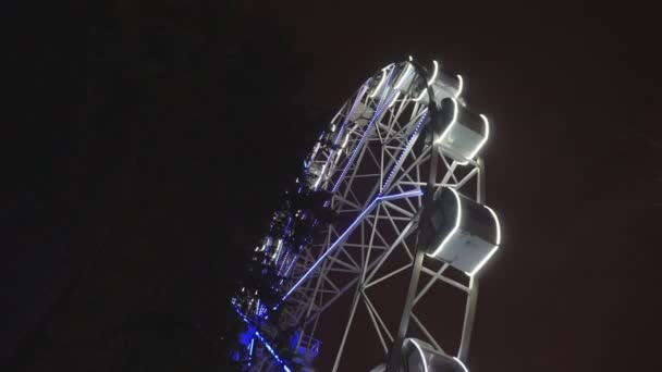 어두운 밤 하늘 아래 놀이 공원에서 회전 관람차 — 비디오