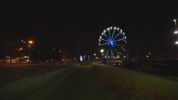 Rueda de la fortuna girando en el parque de atracciones bajo el cielo oscuro de la noche — Vídeos de Stock