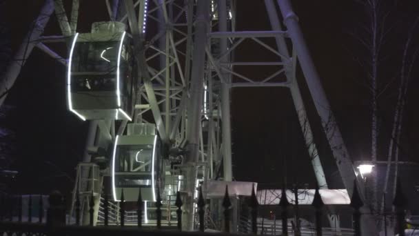 Rueda de la fortuna girando en el parque de atracciones bajo el cielo oscuro de la noche — Vídeo de stock