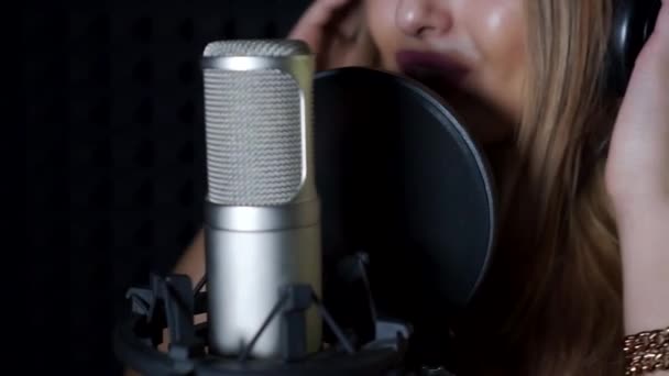 Flickan sjunger i mikrofonen. — Stockvideo