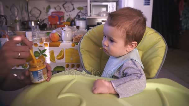 Mamá alimenta al bebé con una cuchara. — Vídeo de stock