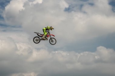 Freestyle Motocross binici hile bir mavi bulut gökyüzü arka plan üzerinde motosiklet ile yürütmektedir. Bir motosiklet üzerinde uçan gökyüzünde. Almanca-Stuntdays, Zerbst - 2017, Juli 08