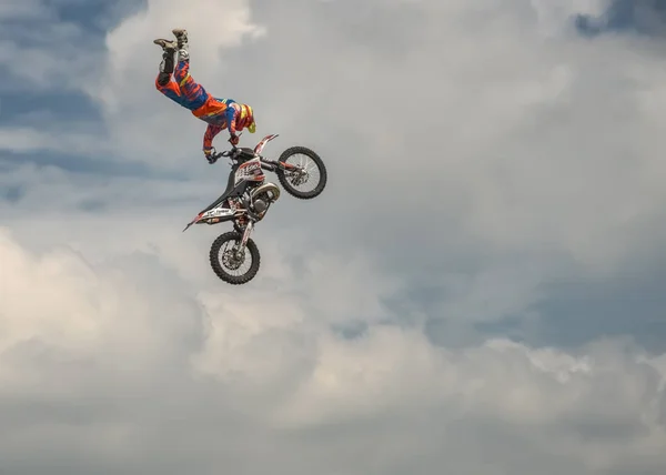 Profesional Freestyle Motocross rider lleva a cabo un truco con la motocicleta en el fondo del cielo azul de la nube. German-Stuntdays, Zerbst - 2017, julio 08 —  Fotos de Stock