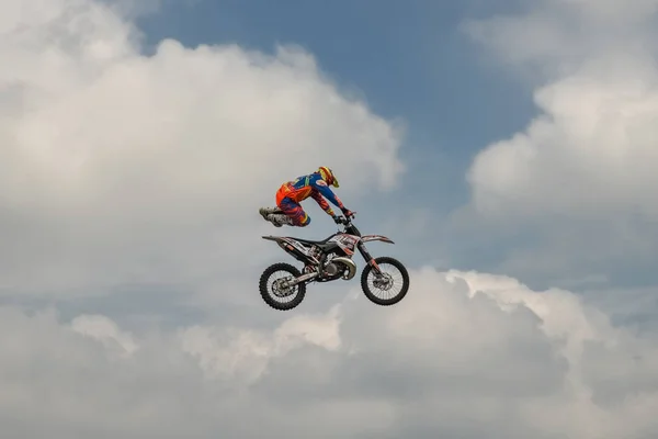 O cavaleiro executa um truque com a motocicleta no fundo do céu azul nuvem. Alemão-Stuntdays, Zerbst - 2017, Juli 08 — Fotografia de Stock