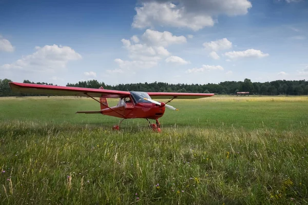 Light aircraft. Light red school airplane on airport grass — Stock Photo, Image