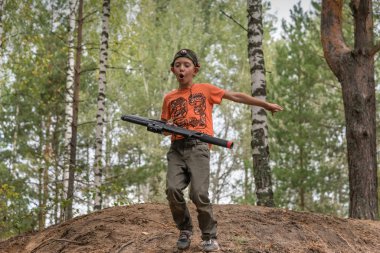 Novgorod, Rusya - 4 Eylül 2016: kızılötesi ışınları fırlatan bir çocuk. Sınıf arkadaşları dışarıda birlikte oynarlar. Laser tag, eğlence, atış oyunu