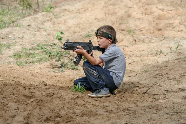 Novgorod, Russie - 04 septembre 2016 : Garçon avec un pistolet laser tag. Les camarades de classe jouent ensemble en plein air. Loisirs sportifs actifs — Photo