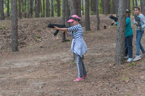 俄罗斯诺夫哥罗德- 2016年9月4日：拥有发射红外光的武器的女孩。 同学们一起在室外玩耍。 激光标签，有趣，充满肾上腺素射击游戏 — 图库照片