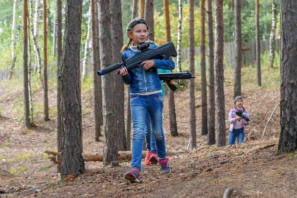 Novgorod, Russie - 04 septembre 2016 : Une fille avec des fusils qui tirent des rayons infrarouges. Les camarades de classe jouent ensemble en plein air. Laser tag, amusant et rempli d'adrénaline jeu de tir — Photo